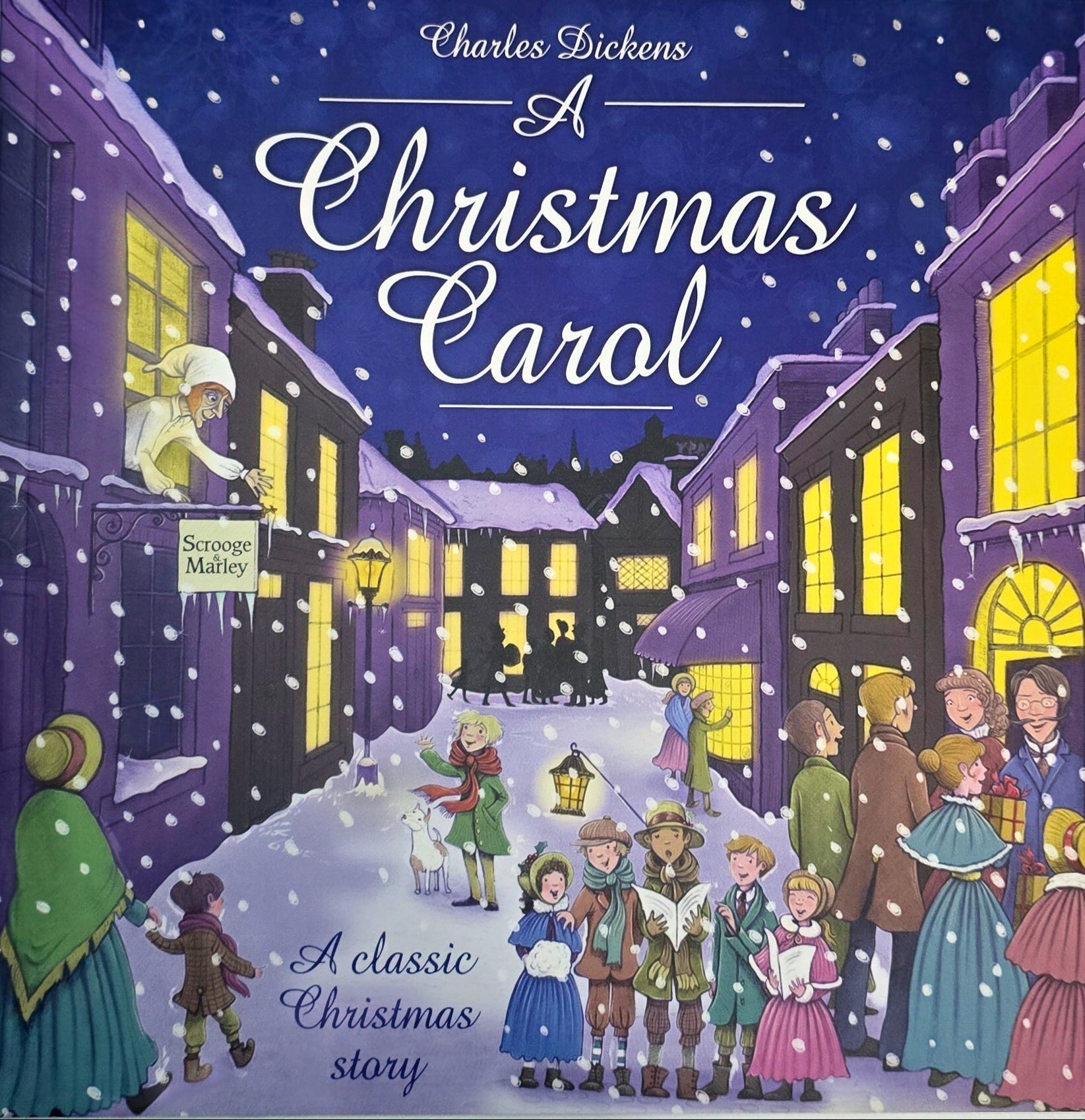 Book cover of 'A Christmas Carol' with illustrated characters and buildings on a snowy night.