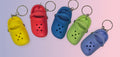 Set of colorful keychains shaped like clogs on a white background