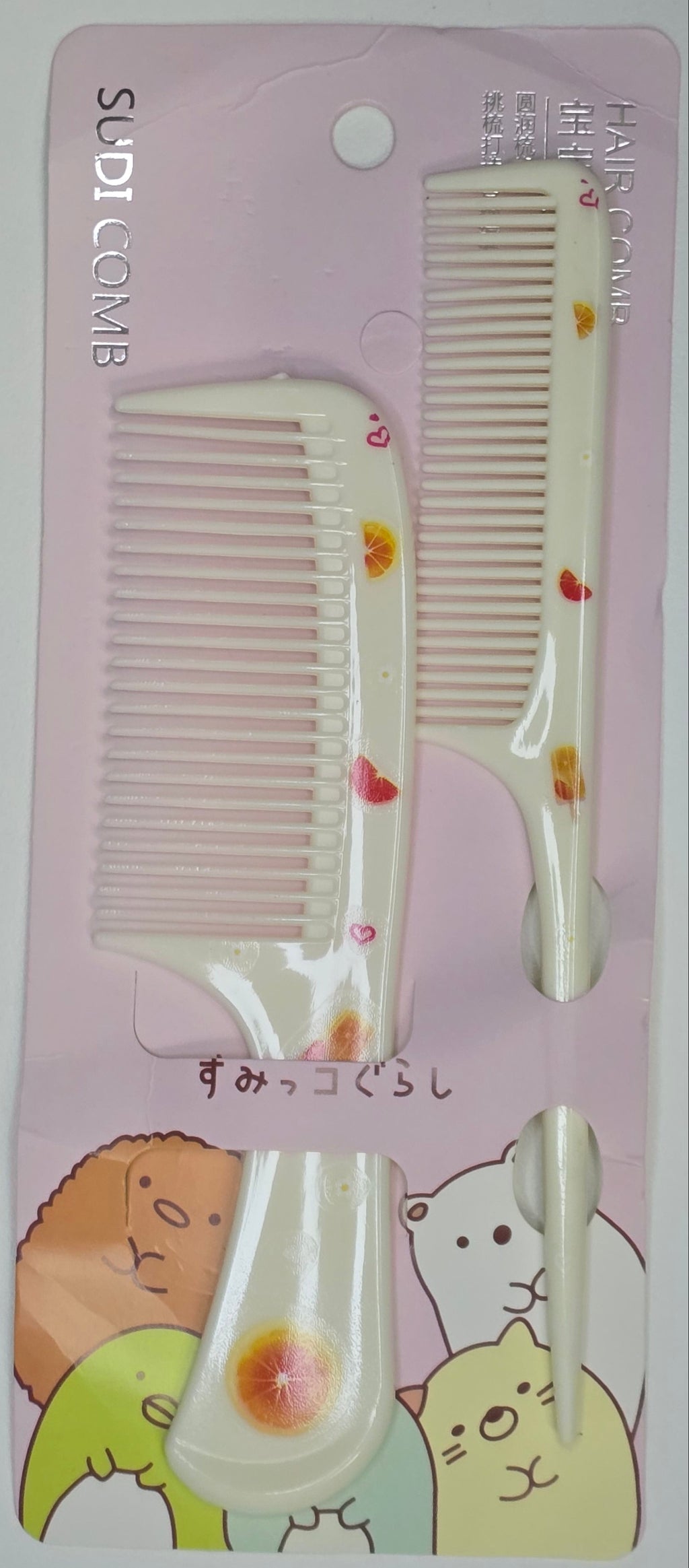 Two combs on a pink card with cartoon designs