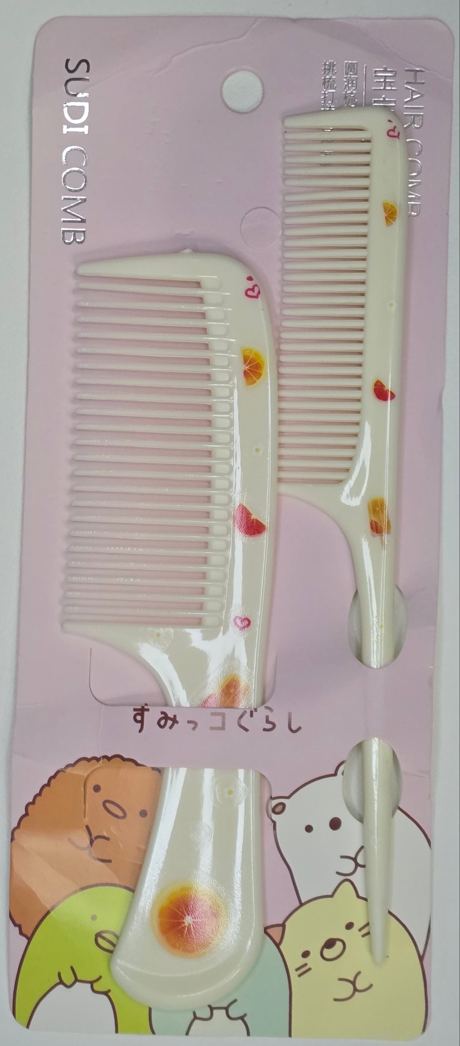 Two combs on a pink card with cartoon designs